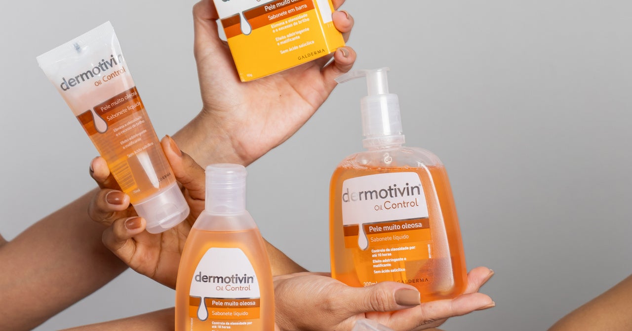 Mãos diversas segurando produtos Dermotivin Oil Control para pele oleosa. Linha completa com sabonete líquido em frasco pump, sabonete em espuma e embalagens laranja-degradê sobre fundo cinza neutro. Demonstração de uso e variedade de formatos.