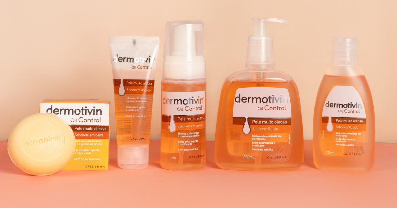 Linha completa Dermotivin Oil Control organizada sobre fundo bege. Da esquerda para direita: sabonete em barra com embalagem amarela, gel de limpeza facial em tubo, sabonete em espuma e dois tamanhos de sabonete líquido. Produtos para pele muito oleosa.